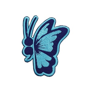 May include: Embroidered butterfly patch in shades of blue. The butterfly design features a dark blue outline with light blue detailing on the wings. The patch is likely for clothing or accessories.