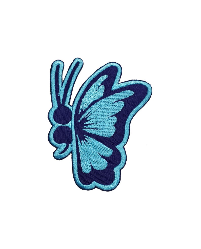 May include: Embroidered butterfly patch in shades of blue. The butterfly design features a dark blue outline with light blue detailing on the wings. The patch is likely for clothing or accessories.