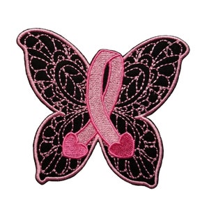May include: Pink ribbon in the shape of a butterfly with black lace wings. The ribbon is tied in a bow with two hearts at the ends.