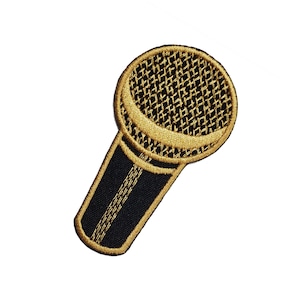 以下が含まれることがあります： 黒いディテールが付いた金のマイクパッチ。マイクは金糸で刺繍されています。