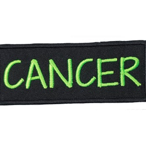 May include: Black patch with green embroidered text that reads "CANCER".
