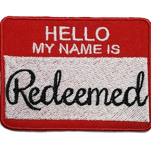 May include: Red embroidered iron-on patch with white text that reads "Hello My Name Is" and the word "Redeemed" in a cursive font.