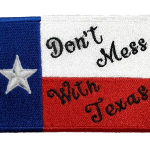 Puede incluir: Parche bordado con la bandera de Texas con las palabras "Don't Mess With Texas" en letras cursivas negras.