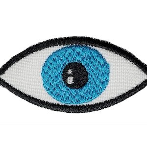 May include: An embroidered patch depicting a blue eye with a black pupil and white sclera. The eye is outlined in black.