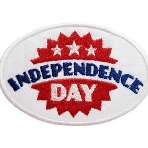 以下が含まれることがあります： 白地に赤、白、青の星と「Independence Day」の文字が刺繍された楕円形のワッペンです。
