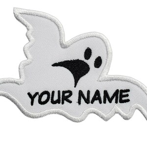 May include: White ghost-shaped iron-on patch with a black paw print and the text "YOUR NAME".