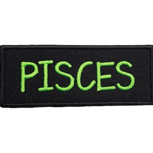 May include: Black rectangular patch with the word "PISCES" embroidered in green.