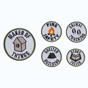 May include: Set of five embroidered patches with a white background and green border. Designs include a birdhouse, campfire, animal tracks, tent, and an open book. Text on the patches includes "Maker of Things", "Fire Safety", "Animal Tracking", "Shelter Building", and "Story Teller".