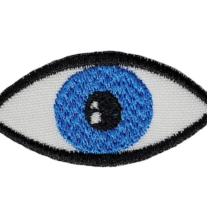 May include: Embroidered eye patch featuring a blue iris, black pupil, and black outline. The eye is set against a white background. This patch can be sewn or ironed onto fabric.