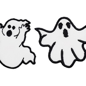 May include: Two white ghost-shaped embroidered patches with black outlines. The ghosts have large eyes and open mouths, suggesting a scream.