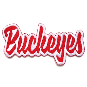 May include: A red and white embroidered patch with the word "Buckeyes" in a cursive font. The patch has a red background with white stitching and a white border. The patch is on a white background.