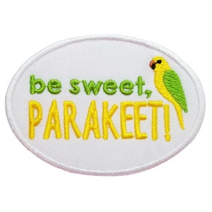 May include: White oval embroidered patch with the text "be sweet, PARakeet!" in yellow and green thread. A yellow and green parakeet is embroidered on the right side of the patch.