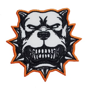 May include: Black and white embroidered patch of a snarling bulldog with a spiked collar. The collar is outlined in orange.