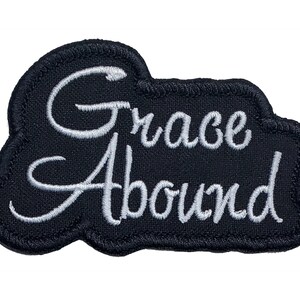 May include: Black embroidered patch with white cursive lettering that reads "Grace Abound".