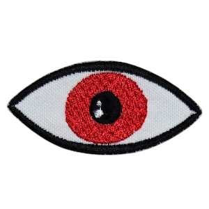 May include: A red eye with a black pupil, embroidered on a white background with a black outline.