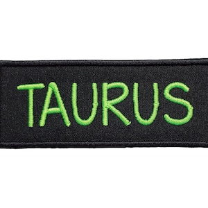 May include: Black embroidered patch with the word "TAURUS" in green lettering.