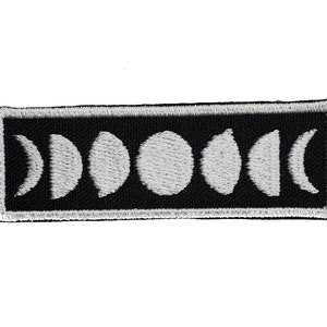 May include: A black and white embroidered patch with a design of the phases of the moon.