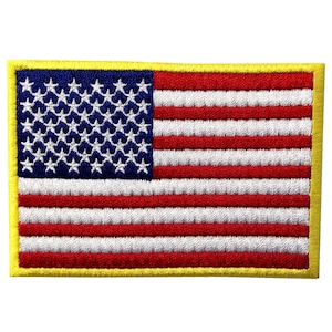 以下が含まれることがあります： 黄色の縁取りが付いた、小さな刺繍のアメリカ国旗のパッチ。旗は赤、白、青で、13本のストライプと50個の星があります。