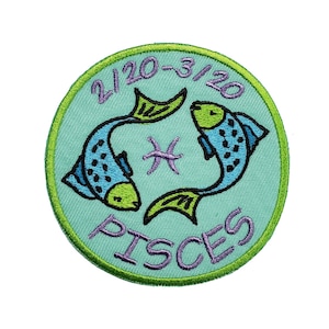 May include: A green and blue embroidered patch with two fish swimming in a circle. The text "2/20-3/20 Pisces" is embroidered in purple on the patch.