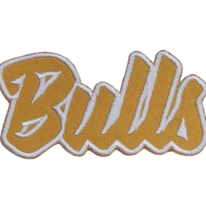 May include: A gold embroidered patch with the word "Bulls" in white lettering.