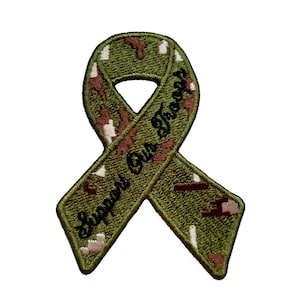 Pode incluir: Fita de camuflagem verde, marrom e branca com o texto "Support Our Troops" bordado em preto.
