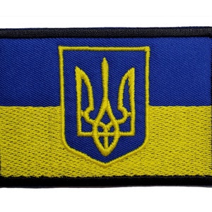 May include: Embroidered patch featuring the Ukrainian flag. The design includes a blue and yellow color scheme, with a gold trident emblem in the center. The patch has a black border.