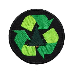 Puede incluir: Parche bordado verde y negro con un símbolo de reciclaje y un árbol verde en el centro.