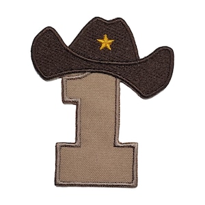May include: A brown felt cowboy hat with a gold star on the front, sitting on top of a tan felt number one.
