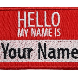 May include: Red fabric name tag with white embroidery that says "Hello My Name Is" and a white fabric nameplate with black embroidery that says "Your Name".