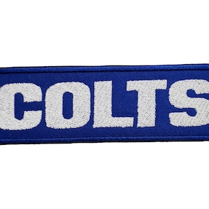 May include: A blue rectangular patch with the word "COLTS" embroidered in white.