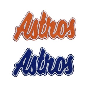 Peut inclure: Deux patchs brodés avec le mot "Astros" en lettres blanches. Le patch du haut est orange avec des lettres blanches. Le patch du bas est bleu avec des lettres blanches.