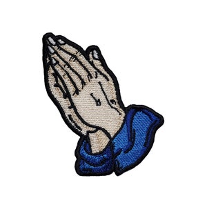 May include: Embroidered patch of two hands clasped in prayer, with a blue sleeve on the bottom half of the patch.