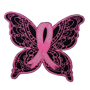 May include: Pink ribbon in the shape of a butterfly. The butterfly is black with a delicate lace design. The ribbon is a symbol of breast cancer awareness.