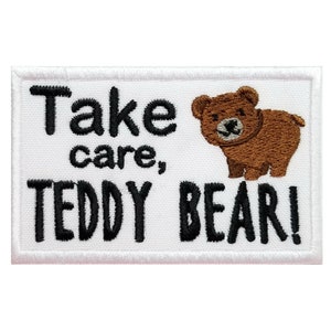 May include: White embroidered patch with black text that reads "Take care, Teddy Bear!" and a brown teddy bear illustration.