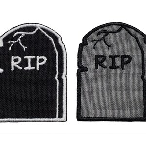 May include: Two embroidered iron-on patches in the shape of a tombstone with the word "RIP" on them. One patch is black with white stitching and the other is gray with black stitching.