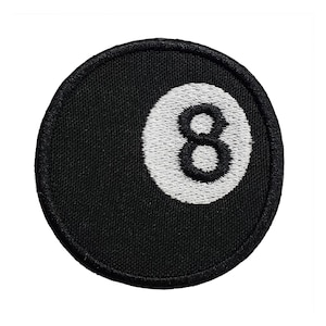 May include: Black and white embroidered patch of a billiard ball with the number 8 on it.