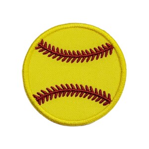 Könnte beinhalten: Gelber Softball mit roten Nähten. Der Softball ist ein runder Patch mit gelbem Hintergrund und roten Nähten.