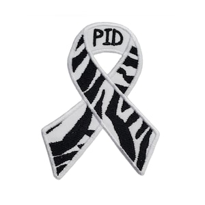May include: Black and white zebra patterned ribbon with the word "PID" embroidered in black on the ribbon.