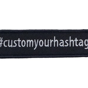 May include: Black rectangular patch with white text that reads "#customyourhashtag".