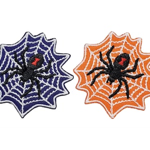 Può includere: Due toppe ricamate da stirare che raffigurano un ragno nero con un punto rosso sulla schiena, seduto su una ragnatela bianca. Una toppa ha uno sfondo blu e l'altra uno sfondo arancione.