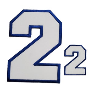 K&ouml;nnte beinhalten: Zwei wei&szlig;e Filzpatches mit blauer Umrandung in Form der Zahl 2. Der gr&ouml;&szlig;ere Patch ist etwa doppelt so gro&szlig; wie der kleinere.