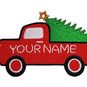 May include: Red pickup truck with a green Christmas tree in the bed. The truck has a white star on top and the words "YOUR NAME" written on the side.