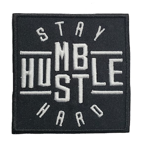 Könnte beinhalten: Schwarzer gestickter Patch mit weißem Text, der "Stay Humble Hustle Hard" lautet.