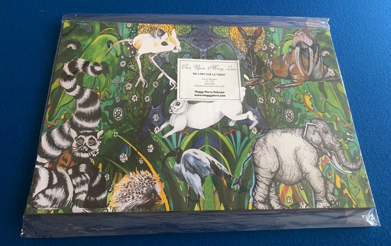 May include: A colorful illustration of various animals in a jungle setting. The animals include a lemur, a rabbit, a bird, a hedgehog, an elephant, a mouse, and a walrus. The illustration is on a green background with a white text box that says "One Upon a Many Lives We Just Sit Sur La Table".