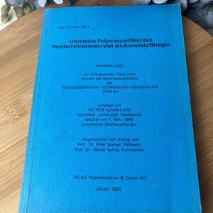 May include: A blue book with German text, titled "Ultrafeine Polymerpartikel aus Polybutylcyanoacrylat als Arzneistoffträger." The book is a dissertation from the EIDGENOSSISCHEN TECHNISCHEN HOCHSCHULE ZÜRICH, published in 1981.