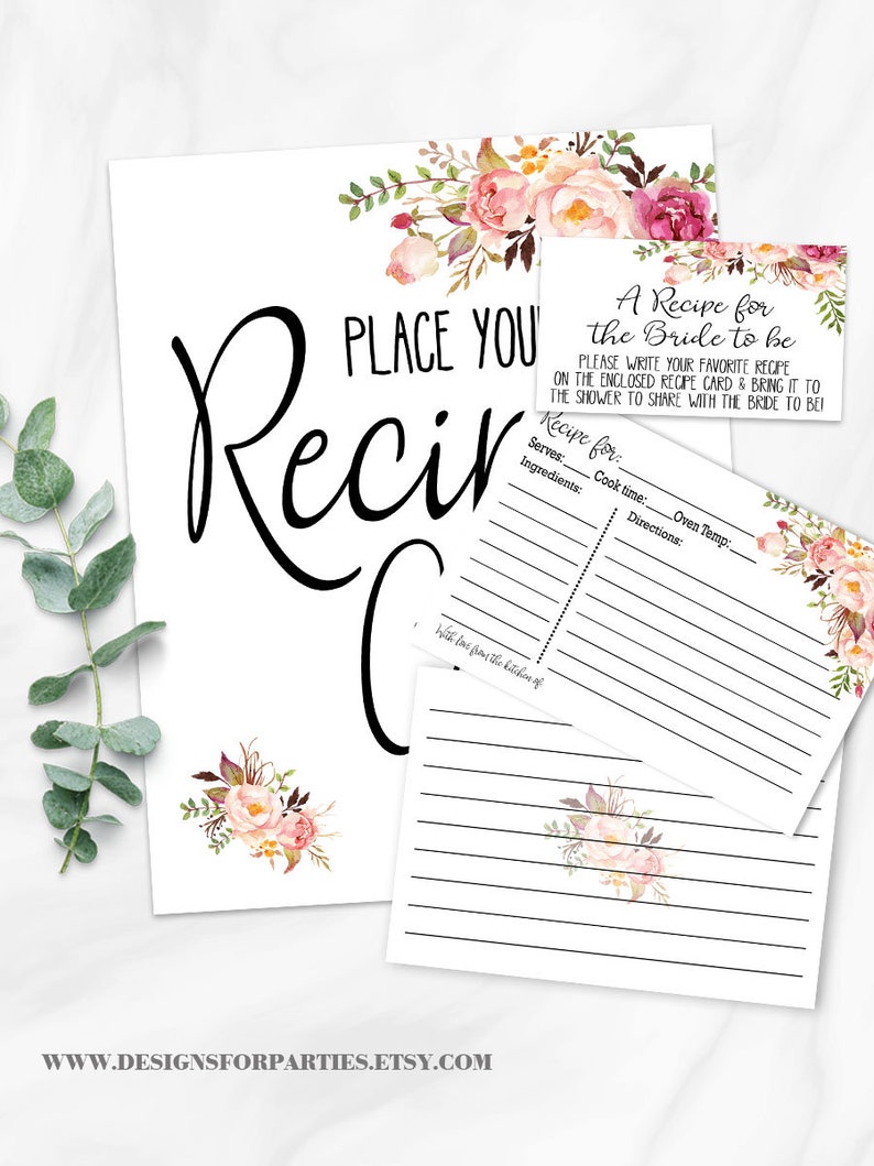 May include: White recipe cards and sign with floral accents. The sign reads "Place Your Recipe" in large black script. Smaller cards say "A Recipe for the Bride to be" and provide space for recipe details. Floral bouquets in pink and burgundy adorn the cards.