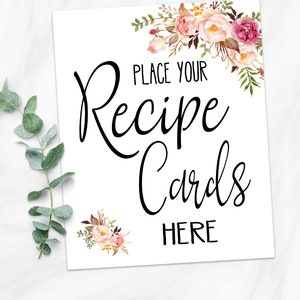 May include: White sign with the text "PLACE YOUR Recipe Cards HERE" in black script. Floral watercolor accents in pink, peach, and burgundy adorn the corners. The Etsy shop URL is at the bottom.