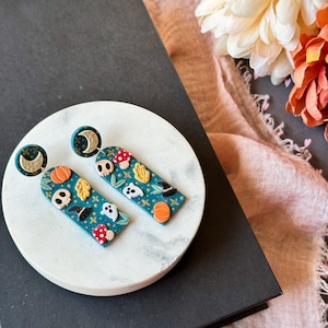 Falloween Cottagecore Witchy inspirierte Polymer Clay dünne Bogen Ohrringe mit Mond, Schädel, Pilz, Kürbis und handbemalten Sternen