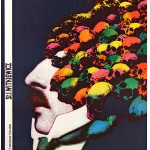 May include: A vintage poster for a play called "J.M.K. Wścieklica" by S.I. Witkiewicz. The poster features a man's face in profile with a colorful skull pattern for hair. The poster is on a dark blue background.