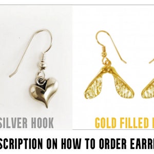 May include: The image displays two pairs of earrings. One pair has sterling silver hooks with heart-shaped charms. The other pair features gold-filled hooks with a maple seed design. Text on the image reads "STERLING SILVER HOOK" and "GOLD FILLED HOOK".